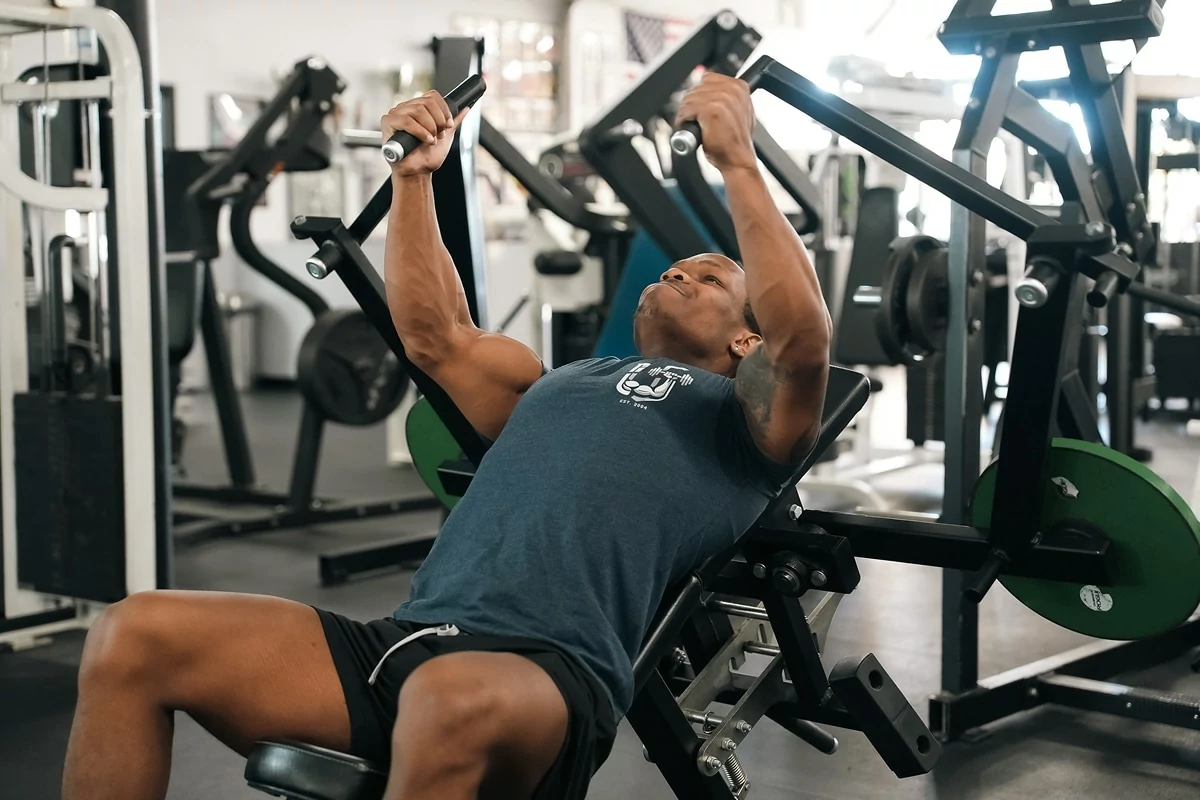 Person seated on chest press machine for upper body workout